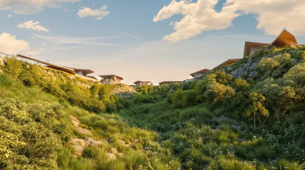 Mira Verde villas along the ridge above a wild meadow in daylight